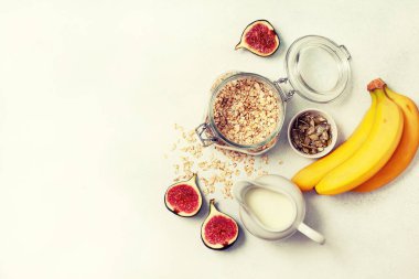 Kahvaltı için malzemeler: yulaf ezmesi, süt, incir, muz, kabak çekirdeği. yukarıdan görüntüleyin. Tonin