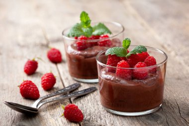 çikolata mousse ile gözlük eski ahşap arka plan üzerinde hizmet veren cam ahududu