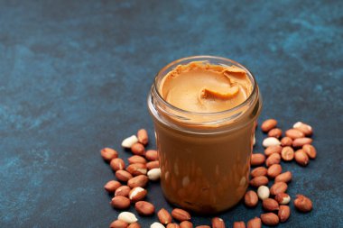 fıstık ezmesi fıstık mavi bir arka plan üzerinde bir cam kavanoza