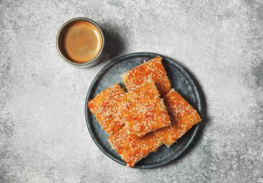 Mavi tabakta salvadorena quesadilla, gri arka planda bir fincan kahve. Yukarıdan görünüm