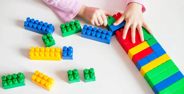 Niña Está Jugando Con Constructor Plástico Multicolor Sentado Una Mesa — Foto de Stock