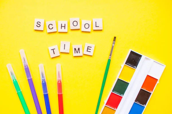 木のブロックからの言葉 学校の時間 と明るい黄色の背景に文房具 — ストック写真