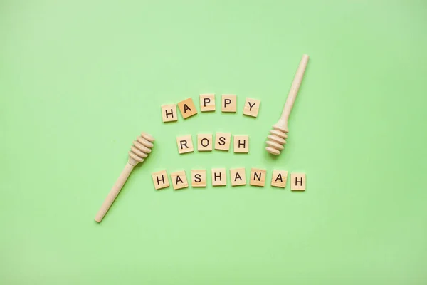 Words from wooden blocks happy rosh hashanah and wooden spoons for honey