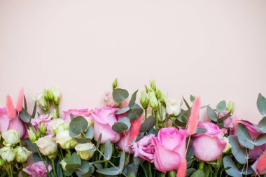 Açık pembe arka planda zarif, dokunaklı bir buket beyaz ve pembe çiçek. Düzen