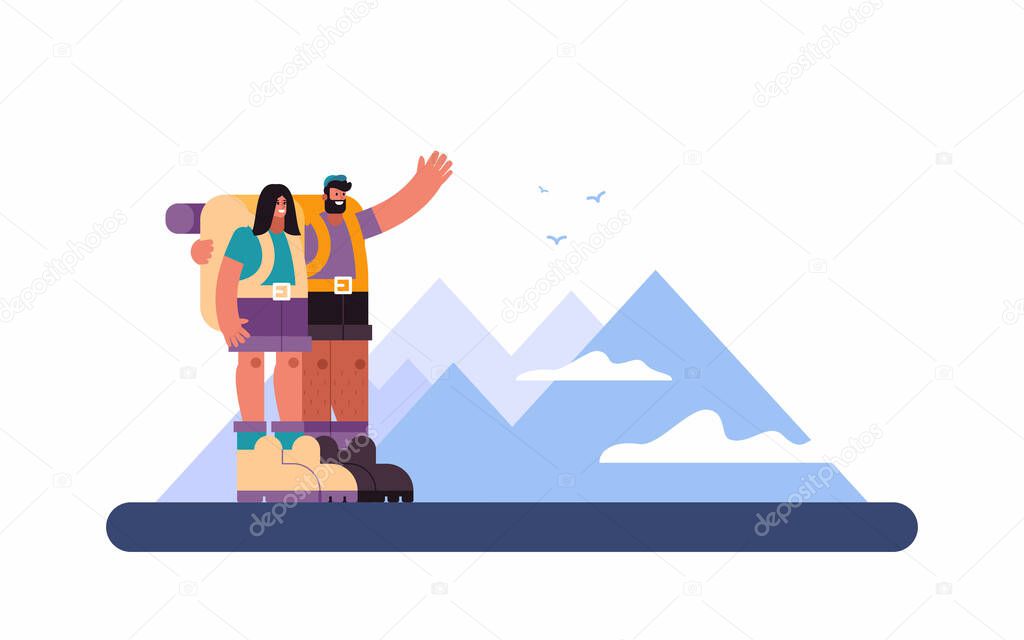 Happy couple of hikers admiring mountain ridge