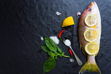 Taze ham kırmızı snappers bir koyu arka plan üzerine yerleştirilen pişirmeye hazır, sağlıklı gıda, üstten görünümü