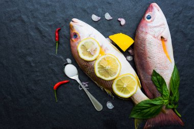 Taze ham kırmızı snappers bir koyu arka plan üzerine yerleştirilen pişirmeye hazır, sağlıklı gıda, üstten görünümü