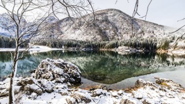 Kışın ilk karı İtalyan Alplerinde bir gölde.