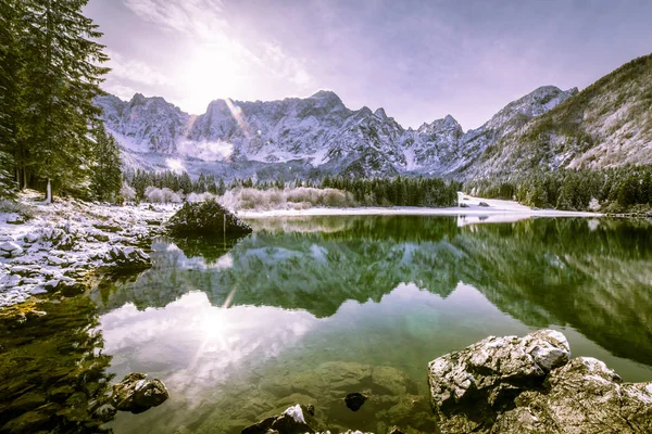 Kışın ilk karı İtalyan Alplerinde bir gölde.