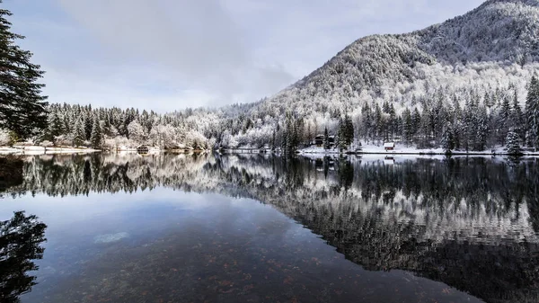 Kışın ilk karı İtalyan Alplerinde bir gölde.