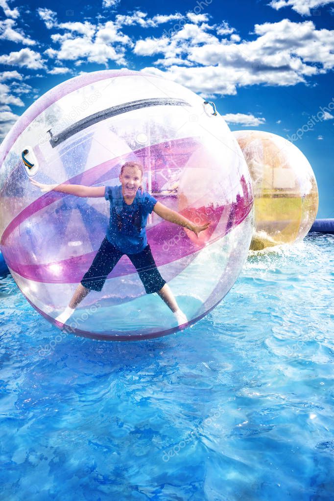 Young girl standing inside a floating water walking ball.