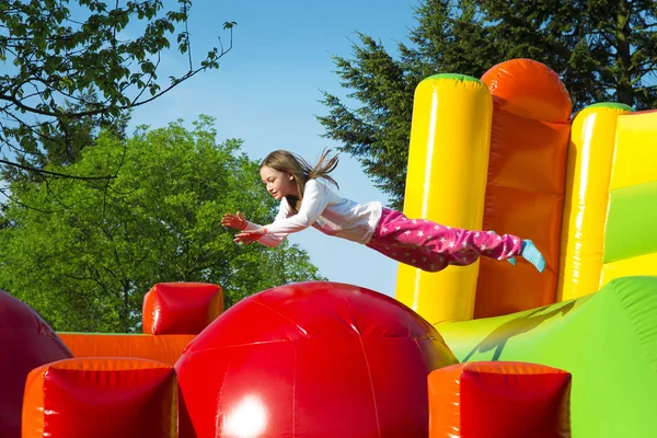Menina pulando em uma bola inflar — Fotografia de Stock