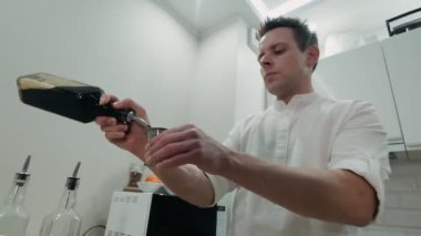 Barmen bir bardak kahve likörü alır ve onu bir zencefilin içine döker.