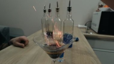 Barmen yanan bir kokteyl serpiyor.