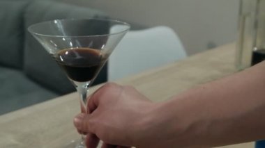 Barmen bardağı içkiyle ileri itiyor.