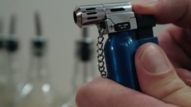 Barmen kokteyli ateşe veriyor, alkollü içecekle tarçın yakıyor.