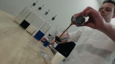 Adam kahve likörünü kokteyl bardağına dolduruyor.