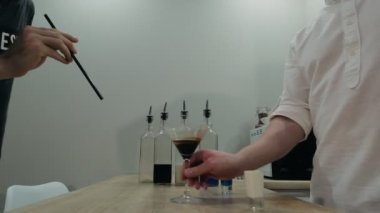 Genç adam alkol kokteyli içiyor. Uzaklaş, yavaş çekim