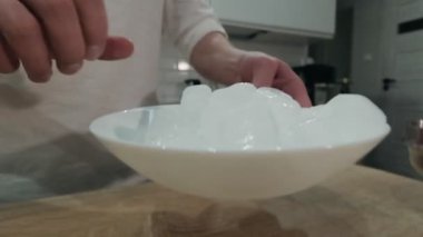 Barmen alkollü kokteyl hazırlarken kristal buz küplerini karıştırıyor.