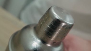 Alkollü kokteyl yapıyorum. Barmen bardağın kapağını açar.