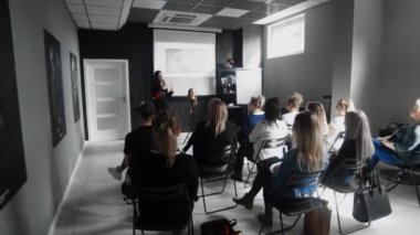 Profesyonel kuaför, saç akademisinde öğrencilere ders veriyor.