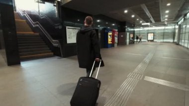 Yolcu bagaj ile metro istasyonunda yürüyor