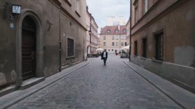 SAVAŞ, POLAND - 8 Mayıs 2019: Eski kasabada sokakta yürüyen yakışıklı sakallı adam