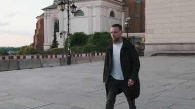 Eski kasabadaki caddede yürüyen yakışıklı sakallı adam. Varşova, Polonya
