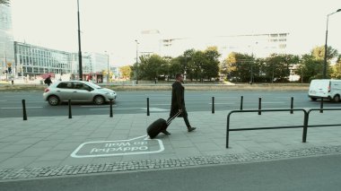 WARsaw, POLAND - 19 Temmuz 2019: Bavullu bir turist şehir merkezinde yürüyor.