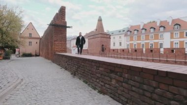 Tuğla duvarda duran yakışıklı sakallı adamın portresi