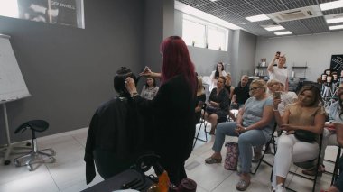 SAVAŞ, POLAND - 9 Haziran 2019: Saç akademisinde erkek tıraşı öğreten profesyonel kuaför