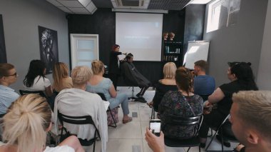 SAVAŞ, POLAND - 9 Haziran 2019: Saç akademisinde erkek tıraşı öğreten profesyonel kuaför