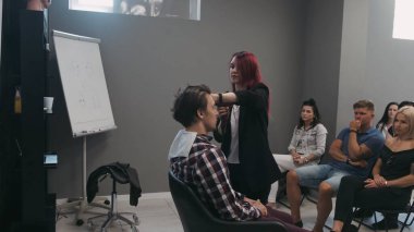 SAVAŞ, POLAND - 9 Haziran 2019: Saç akademisinde erkek tıraşı öğreten profesyonel kuaför