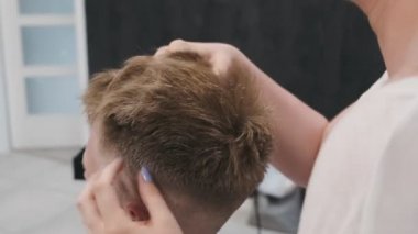 Kapalı stilistler saç şekillendirmeyi bitirmek için elleri kullanır.