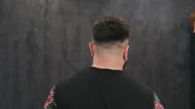 Kuaförde saç kesiminden sonra poz veren genç bir adam. Kapat.