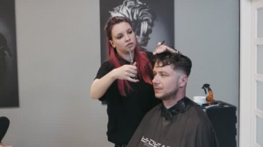 SAVAŞ, POLAND - 10 Haziran 2019: Erkek saçını tarayan profesyonel kadın kuaför
