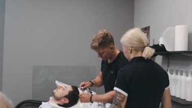 WARsaw, POLAND - 10 Haziran 2019: profesyonel kadın kuaför erkek saçını tarıyor. Yaklaşın, ağır çekim.