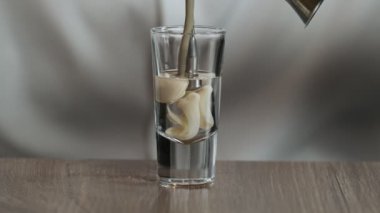 Barmen zencefilden kokteyl bardağına sambuka ile İrlanda kreması döker. Kapat.