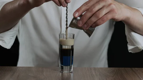 Lexus Kokteyli hazırlanıyor. Barmen bardağa İrlanda kremi döküyor.