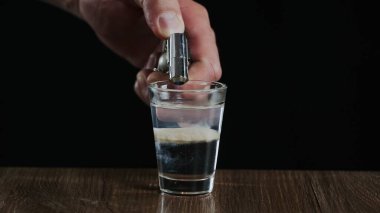 Barmen, Sambuca ve İrlanda kremalı alkollü bir kokteyli ateşe veriyor.