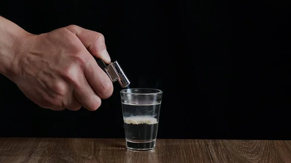 Barmen, Sambuca ve İrlanda kremalı alkollü bir kokteyli ateşe veriyor.