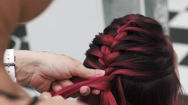 赤い色の女性の髪に編組を果たしているプロの美容師 — ストック写真