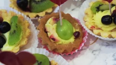 Meyve ve böğürtlenlerle süslenmiş küçük güzel kremalı pasta.