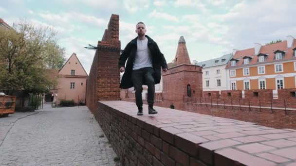 Yakışıklı Sakallı Adam Tuğla Duvar Boyunca Yürüyor Zıplıyor Kaçıyor — Stok video