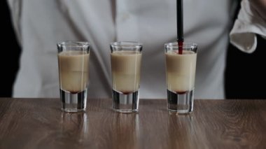 Barmen pipetten bir damla nar şurubu damlatıyor.