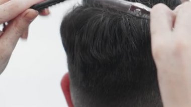 Erkek saçını tarayıp kesen profesyonel bir kadın kuaför.