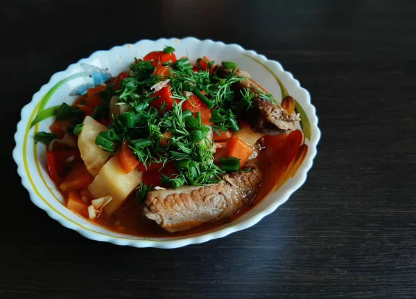 Lagman, yüksek beyaz tabakta bir tabak Özbek mutfağı. Yanında domuz kaburgası, erişte, patates ve sebze..