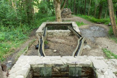 Büyük metal borudan göle bir sürü su fışkırıyor. Su deposunu dolduruyor.