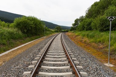 bir tren bahar yeşil alan dik döner. gökyüzü parlak mavi ile beyaz bulut