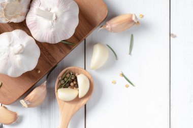 Sarımsak ve biber beyaz tahta arka plan, tahta kaşık üzerinde madde gıda ve bitki kavramı